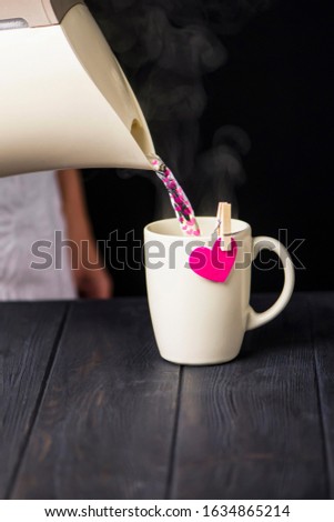 cup with a heart on a clothespin on a dark wooden background