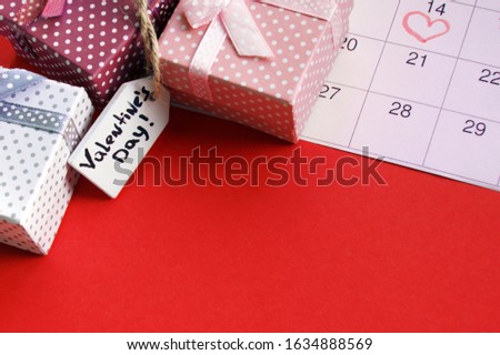 Mini gift boxes with wood tag and the calendar is marked on February 14, concept of Valentine's, anniversary. Top view
