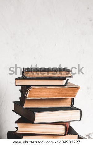 Education and reading concept, group of old colorful books on the white table on the gray background