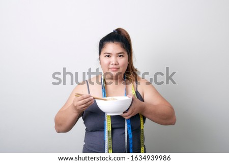Fat asian woman in exercise set with tape measure and eating noodle no white, Weight and health care concept
