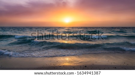 Magical and so beautiful sunset at the beach during winter time in Dubai - United Arab Emirates. Wavy sea during stunning sunset. 