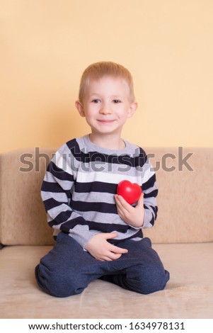Charming blond kid holding a love symbol