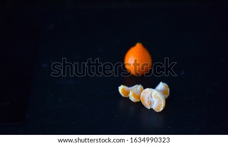 orange Mandarin slices on a black background