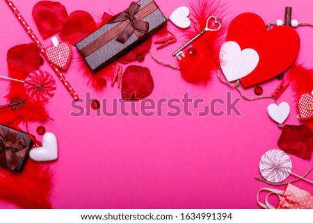 Table top view image of decoration valentine's day background concept. Flat lay arrangement of red shape & gift box with essential items on modern pastel pink paper with middle space for text.