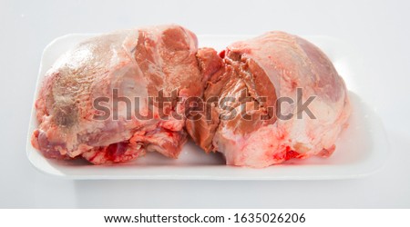 Close up of raw pig's cheeks on white table, no people