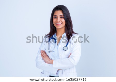 Medical concept of Indian beautiful female doctor in white coat with stethoscope, waist up. Medical student. Woman hospital worker looking at camera and smiling, studio, gray background Royalty-Free Stock Photo #1635029716