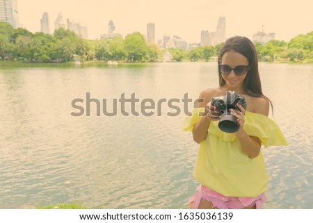 Young beautiful tourist woman with camera exploring the city