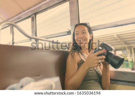 Young beautiful tourist woman with camera exploring the city