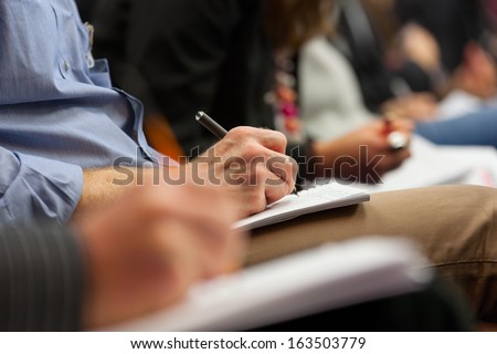 Close-up of Hands holding pens and making notes at the conference Royalty-Free Stock Photo #163503779