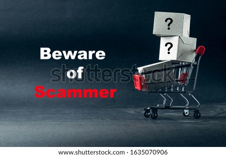 Words BEWARE OF SCAMMER on dark background with shopping cart. Business, Copy space and online shopping concept. Selective focus