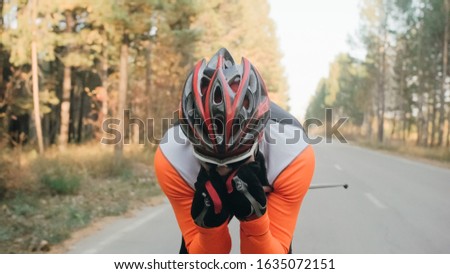 Training an athlete on the roller skaters. Biathlon ride on the roller skis with ski poles, in the helmet. Autumn workout. Roller sport. Adult man riding on skates.