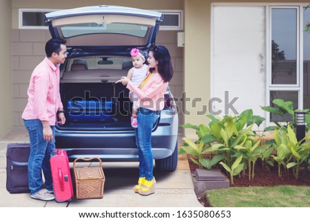 Picture of asian family preparing suitcase to the car for holiday while standing in the garage