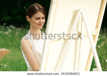young woman draws a picture on canvas