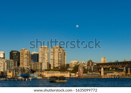 Sydney suburb MilsionsPoint with residential and commercial buildings and full moon above 