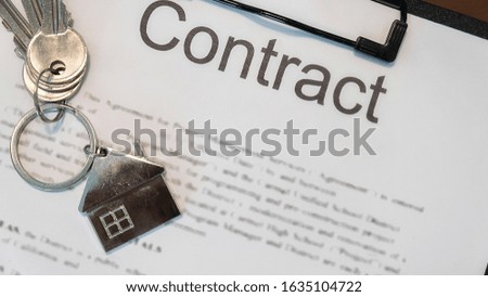 Key with House keychain on contract document.