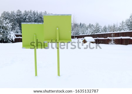 A two green wooden shovels on the background of winter landscape.