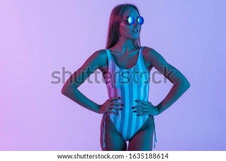 Young beautiful woman wearing striped pink swimsuit swimwear over isolated background