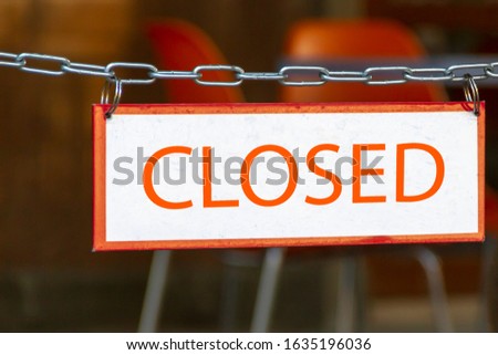 Sign closed hanging in front of cafe entrance on the street