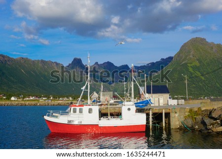 red ship in the Bay against the background of mountains