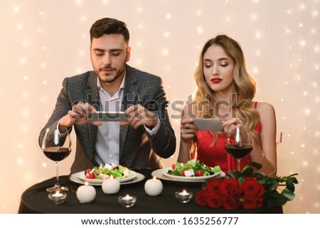 Food Bloggers. Couple Taking Photo Of Their Plates Using Smartphones During Romantic Date In Restaurant, Making Content For Social Networks