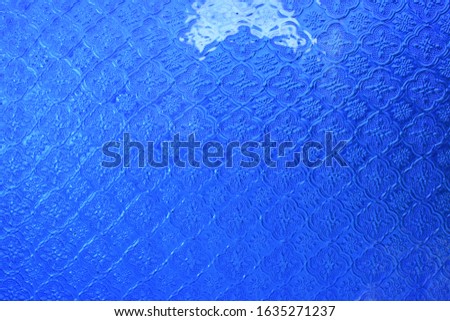 close up blue glass with reflective light pattern