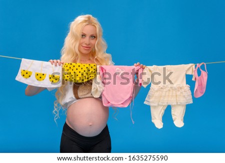 Blonde pregnant woman and things for the baby.