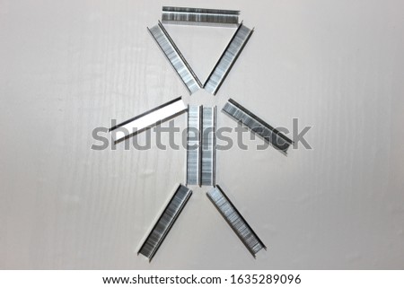 A man laid out of staples for a stapler. Figure from brackets on a white background. The man from the office.