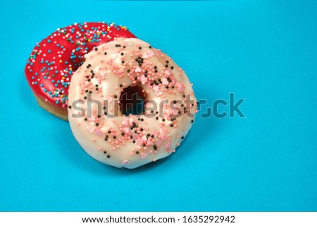 doughnuts with icing and topping on a blue background, space for text