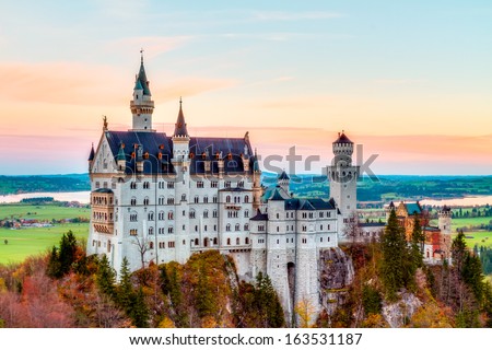 Neuschwanstein, Lovely Autumn Landscape Panorama Picture of the fairy tale castle near Munich in Bavaria, Germany with colorful trees in the morning hours