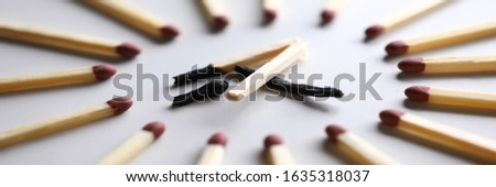 Broken burned out match in surrounded by evil intact fellows close-up. Dominance and cruelty among people concept Royalty-Free Stock Photo #1635318037