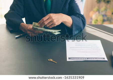The customer pays the real estate agent after signing a contract to buy a house, in dollars.