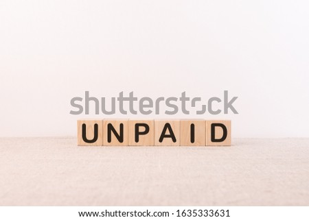 Unpaid word from building blocks on a light background