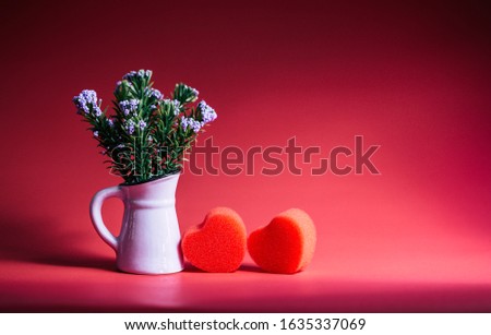 Red double hearts sponge with flower vase on red background, valentine’s day
