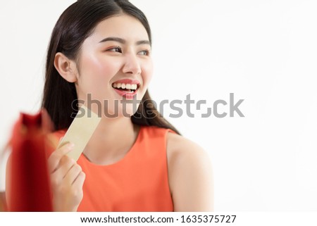 Picture showing smart attractive young asian girl holding credit card with happiness and joyful. Online shopping payment and e-commerce concept.
