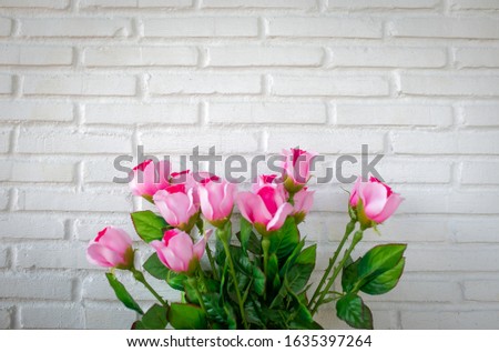 Roses bouquet on white brick wall background with copy space.