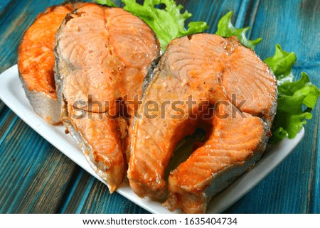 Tasty healthy fried fish fillet on wooden background