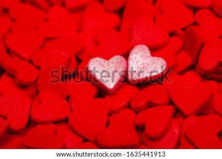Two sweet loving hearts among many red hearts. The concept of St. Valentine's Day, love, couple, sweets