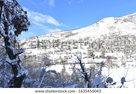 Winter landscape with small mountain village on a snowy slope with blue sky. Ancares, Lugo, Galicia, Spain.