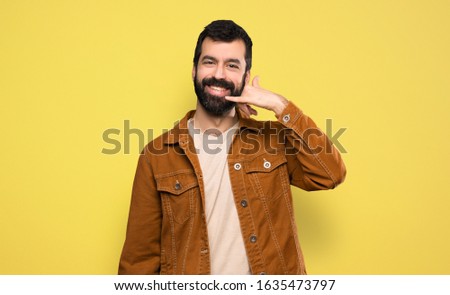 Handsome man with beard making phone gesture. Call me back sign