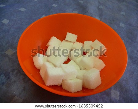 sugar cubes lie in an orange bowl