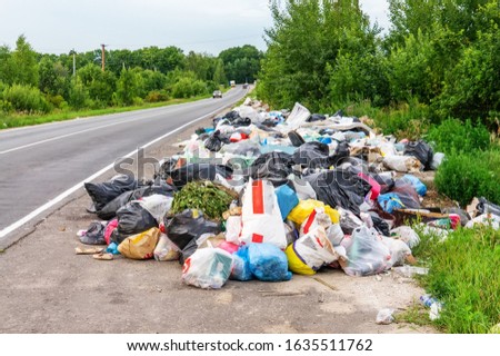 a pile of garbage bags and other debris on the side of the road. Environmental disaster. The collection of waste for recycling.