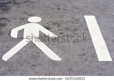 Walk way sign white painted on the floor.One icons walking on gray asphalt.Outdoor shoot background.