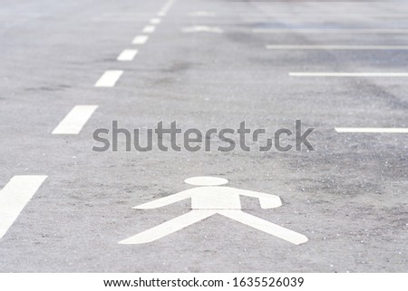 Walk way sign white painted on the floor.One icons walking on gray asphalt.Outdoor shoot background.