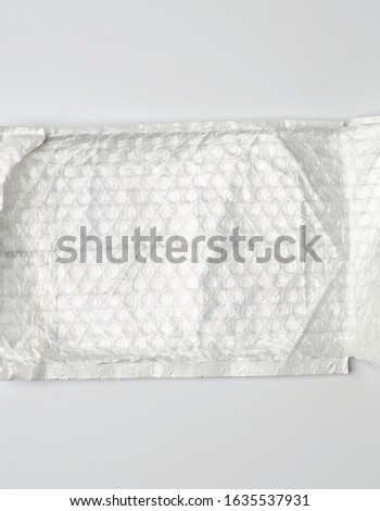 fragment of a transparent film with air for the transportation of parcels is glued on white polyethylene, inside of the envelope