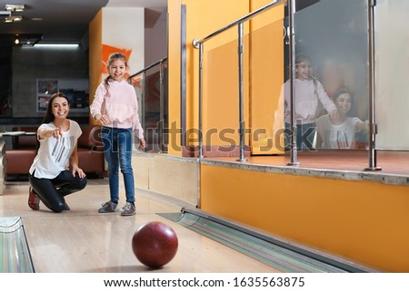 Mother and daughter spending time together in bowling club