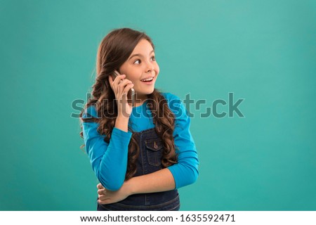 Glad to hear. Modern gadget. Upbringing and development. Little girl call mobile phone blue background. Cute kid hold smartphone. Mobile conversation. Mobile communication. Information and news.