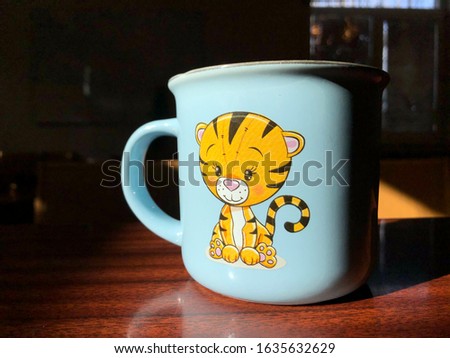 blue cup with a tiger in the sun