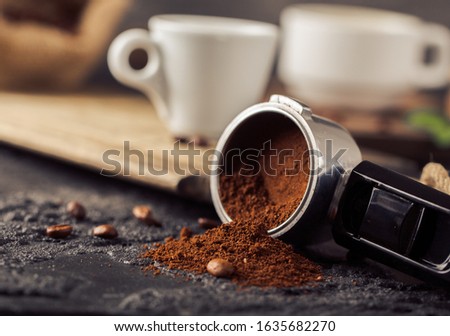 Ground coffee and coffee beans on old cafe table. 