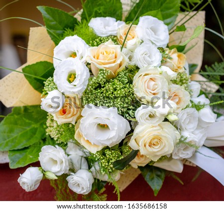 Beautiful bouquet of fresh rose flower and eustoma in cream and white colors. Floral backdrop. Close-up picture