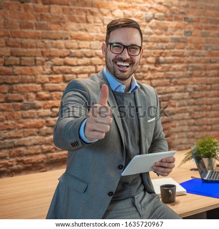 Cheerful businessman thumbs up posing and smiling at camera. Businessman showing OK sign with his thumb up. Business Concept Portrait Handsome Business man showing thumb up and smiling confident face